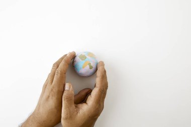 Dünya. Elini tut planet Earth dünya plastiline sembolü beyaz arka plan üstten görünüm alanı metin için