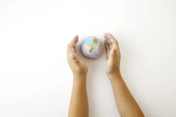 Earth. Hand hold plastiline symbol of planet Earth globe on white background top view space for text