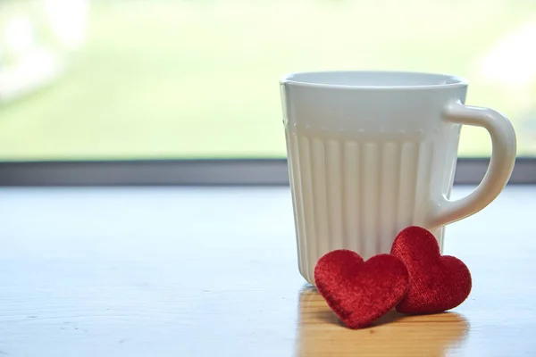Valentine\'s day concept with hearts and cup over green background