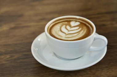 Kalp Desenli güzel latte sanat rustik ahşap zemin üzerine beyaz bir fincan kahve