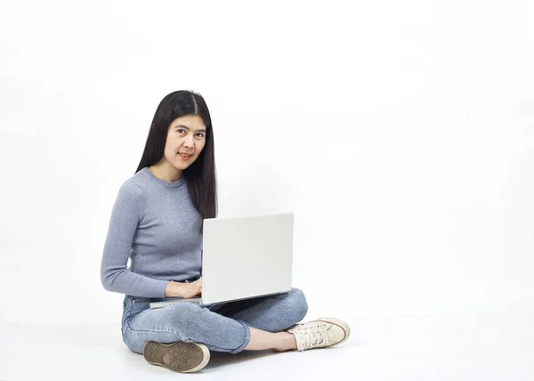 经营理念 一个微笑的休闲女孩拿着笔记本电脑 而坐在地板上和快乐的手势在白色背景的肖像的肖像 — 图库照片
