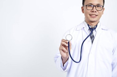 Doktor holding stetoskop beyaz arka plan üzerinde. Asyalı erkek modeli, konsept kozmetik cerrahi