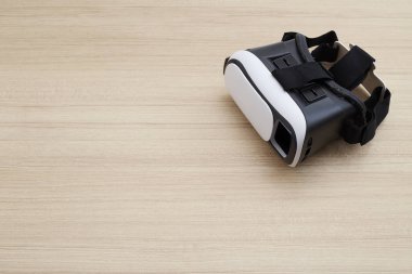 Sanal gerçeklik gözlük kask kulaklık ahşap arka plan üzerinde. Sanal gerçeklik ile Smartphone kullanarak tarih Çrş. Teknoloji, simülasyon, yüksek teknoloji, video oyunu kavramı. Afiş