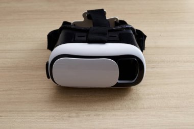 Sanal gerçeklik gözlük kask kulaklık ahşap arka plan üzerinde. Sanal gerçeklik ile Smartphone kullanarak tarih Çrş. Teknoloji, simülasyon, yüksek teknoloji, video oyunu kavramı. Afiş