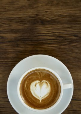 Kalp Desenli güzel latte sanat rustik ahşap zemin üzerine beyaz bir fincan kahve