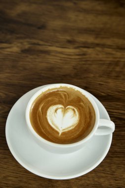 Kalp Desenli güzel latte sanat rustik ahşap zemin üzerine beyaz bir fincan kahve