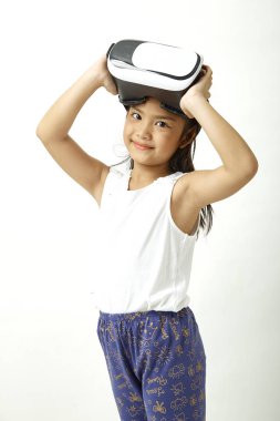 Sevimli kız sanal gerçeklik kulaklık ile eğleniyor. İnovasyon teknolojisi ve eğitim kavramı. beyaz arka plan