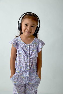 Kulaklık Asya Küçük kız müzik dinlerken ve kopyalama alanı alanına bakıyor