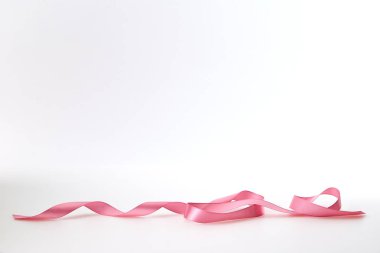 Beyaz arka plan üzerine kıvrılmış pembe şerit, tasarım için boş alan