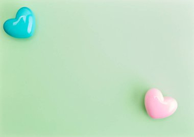 Yeşil kağıt arka plan üzerinde pastel mavi kalp ile Pastel pembe kalp, sevgililer günü kavramı. içeriğiniz için negatif alan ile minimal stil kavramı