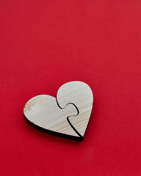Heart of two pieces of a puzzle, heart shape wood for concept Valentine's Day red  background  copy space, top view