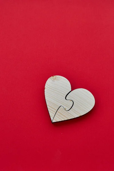Heart of two pieces of a puzzle, heart shape wood for concept Valentine's Day red  background  copy space, top view