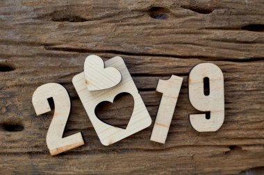 2019 kahverengi ahşap dokulu arka plan üzerinde yatan ahşap pürüzsüz temiz kalpler. Yazıt veya diğer nesneler için boş kopyalama alanı