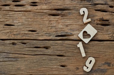 2019 kahverengi ahşap dokulu arka plan üzerinde yatan ahşap pürüzsüz temiz kalpler. Yazıt veya diğer nesneler için boş kopyalama alanı