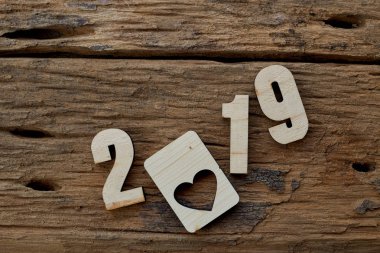 2019 kahverengi ahşap dokulu arka plan üzerinde yatan ahşap pürüzsüz temiz kalpler. Yazıt veya diğer nesneler için boş kopyalama alanı