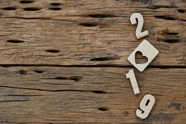 2019 kahverengi ahşap dokulu arka plan üzerinde yatan ahşap pürüzsüz temiz kalpler. Yazıt veya diğer nesneler için boş kopyalama alanı