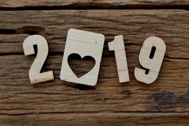 2019 kahverengi ahşap dokulu arka plan üzerinde yatan ahşap pürüzsüz temiz kalpler. Yazıt veya diğer nesneler için boş kopyalama alanı