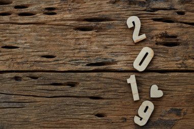 2019 kahverengi ahşap dokulu arka plan üzerinde yatan ahşap pürüzsüz temiz kalpler. Yazıt veya diğer nesneler için boş kopyalama alanı