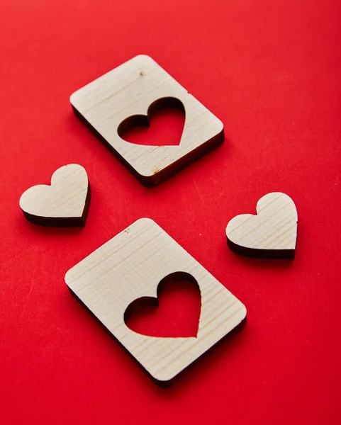 Jigsaw Puzzle form the Wooden Love hearts on texture red paper background. Valentines day card concept