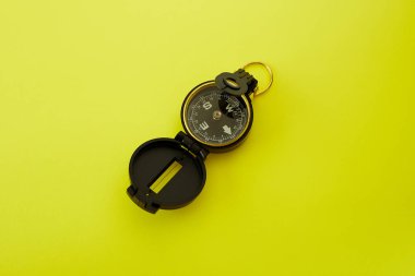 Parlak sarı arka planda Minimal Pusula'yı kapatın , Kopyalama alanı ile yukarıda seyahat kavramı.