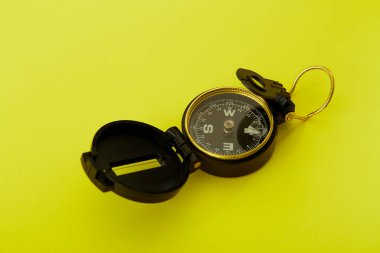 Parlak sarı arka planda Minimal Pusula'yı kapatın , Kopyalama alanı ile yukarıda seyahat kavramı.