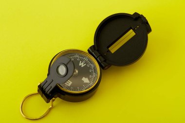 Parlak sarı arka planda Minimal Pusula'yı kapatın , Kopyalama alanı ile yukarıda seyahat kavramı.