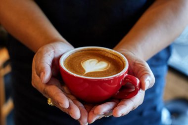 tatlı bir kadın tutarak kahve kalp simgesi olan