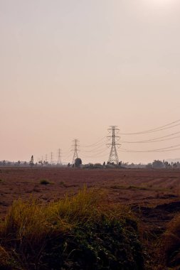 Gün batımında iletim güç hatları ile elektrik direğine