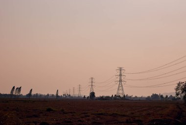 Gün batımında iletim güç hatları ile elektrik direğine