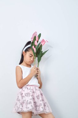 Pembe lale duvar parlak gri arka plan tutan paskalya tavşanı kulakları ile Sevimli küçük kız, Konsept büyük satış bahar arka plan