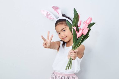 Pembe lale duvar parlak gri arka plan tutan paskalya tavşanı kulakları ile Sevimli küçük kız, Konsept büyük satış bahar arka plan