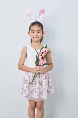 Pembe lale duvar parlak gri arka plan tutan paskalya tavşanı kulakları ile Sevimli küçük kız, Konsept büyük satış bahar arka plan