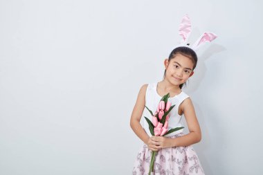 Pembe lale duvar parlak gri arka plan tutan paskalya tavşanı kulakları ile Sevimli küçük kız, Konsept büyük satış bahar arka plan