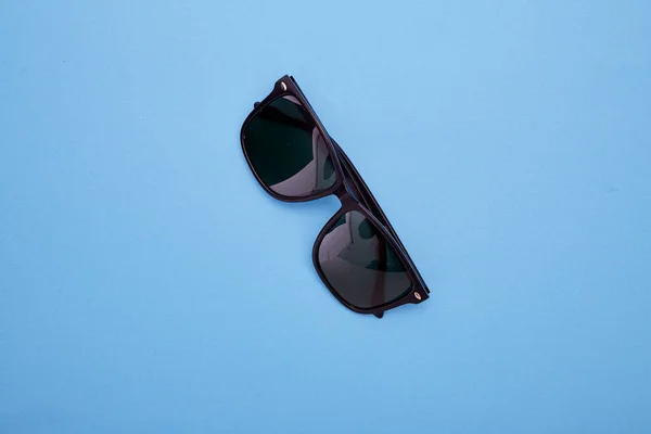 Black sunglasses on a blue — Stock Photo, Image