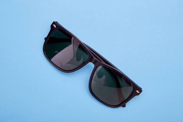 Schwarze Sonnenbrille auf blauem Grund — Stockfoto