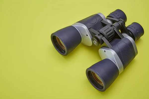 双筒望远镜银色和灰色在黄色背景 — 图库照片