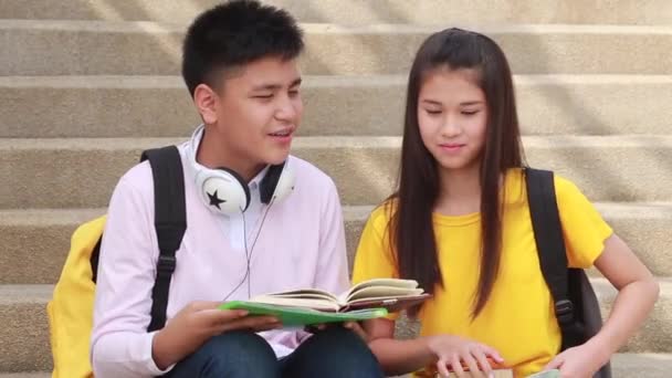 Μαθητές Φίλοι Κάθονται Στις Σκάλες Χρησιμοποιώντας Βιβλίο — Αρχείο Βίντεο