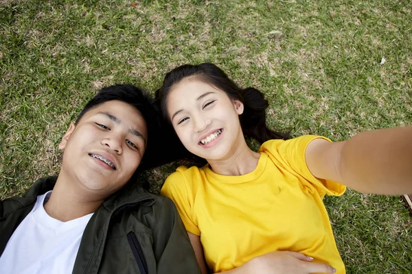 Nastolatków z książek, leżącego na zielonej trawie — Zdjęcie stockowe