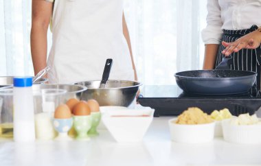 Genç kadın mutfakta tatlı kek pişiriyor.