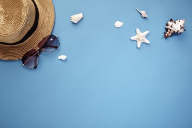 şapka akıllı telefon ve güneş gözlüğü mavi arka plan