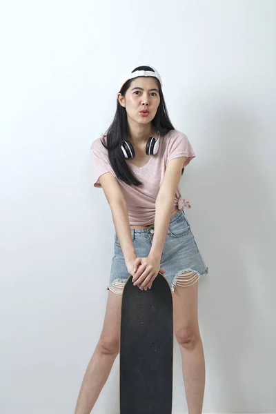 Mooie Aziatische meisje Holding skateboard — Stockfoto