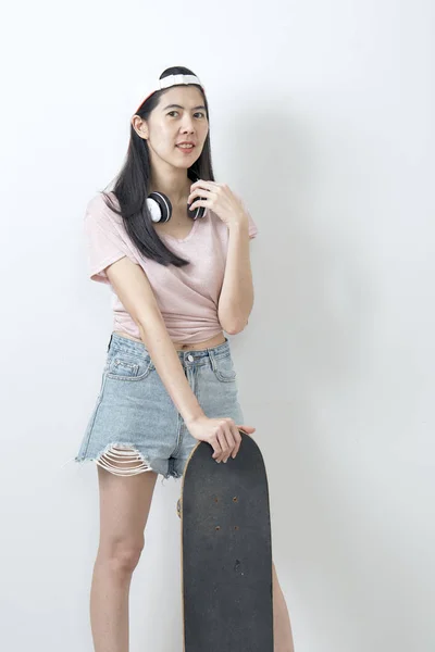Красива азіатська дівчина тримає скейтборд — стокове фото