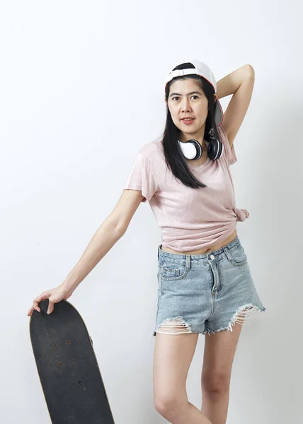 Beautiful asian girl holding skateboard — Stock Photo, Image