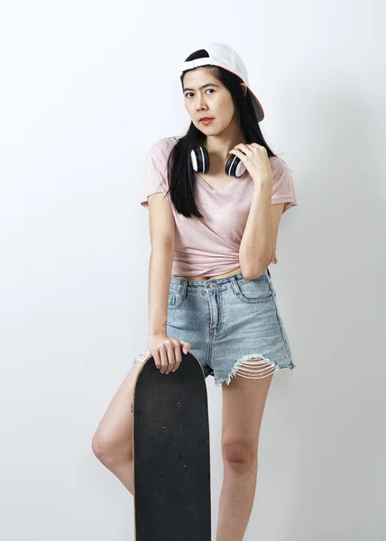 Красива азіатська дівчина тримає скейтборд — стокове фото