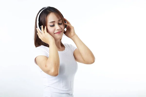 Fones de ouvido mulher ouvir música no branco — Fotografia de Stock