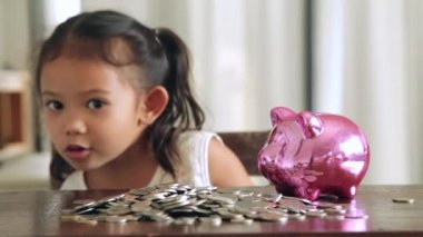 Sevimli kız evde piggy banka para koyarak
