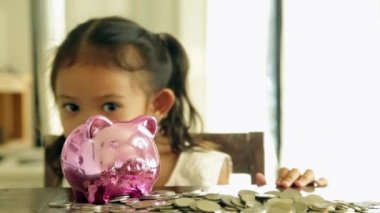 Sevimli kız evde piggy banka para koyarak