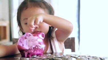 Sevimli kız evde piggy banka para koyarak