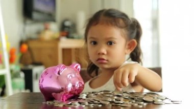 Sevimli kız evde piggy banka para koyarak