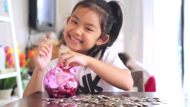 Cute Girl Putting Coins Piggy Bank Home — Stock Video